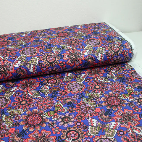 Coral butterfly print cotton with purple background by the meter
